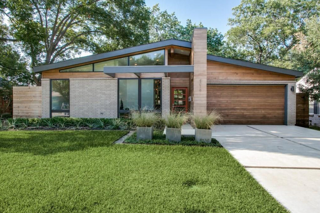 Mid-century modern home exterior featuring clean geometric lines, mixed wood and panel siding, and minimalist landscaping. Design by DesignX Studios.