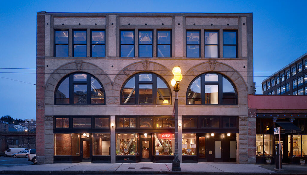 Adaptive Reuse in Architecture, example showcasing a restored historic building with preserved facade and modern interior design in an urban setting.