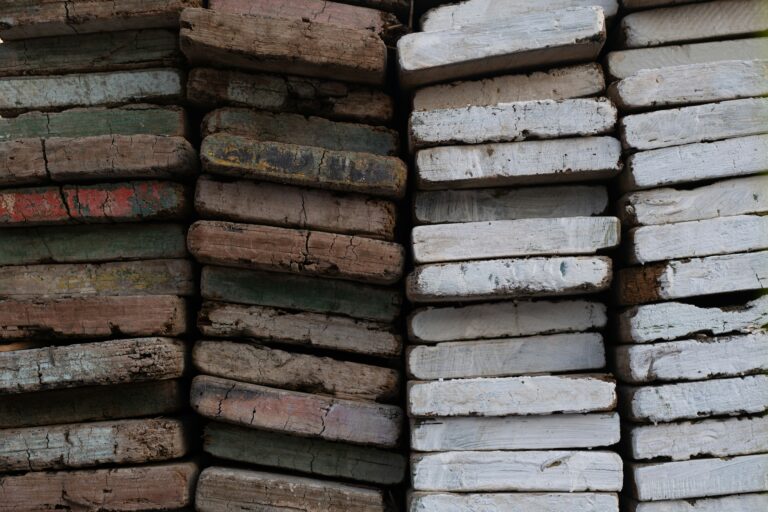 Sustainable Materials and Modern Construction: An image showcasing a pile of reclaimed lumber on the left the wood is brown, on the right the wood is white.